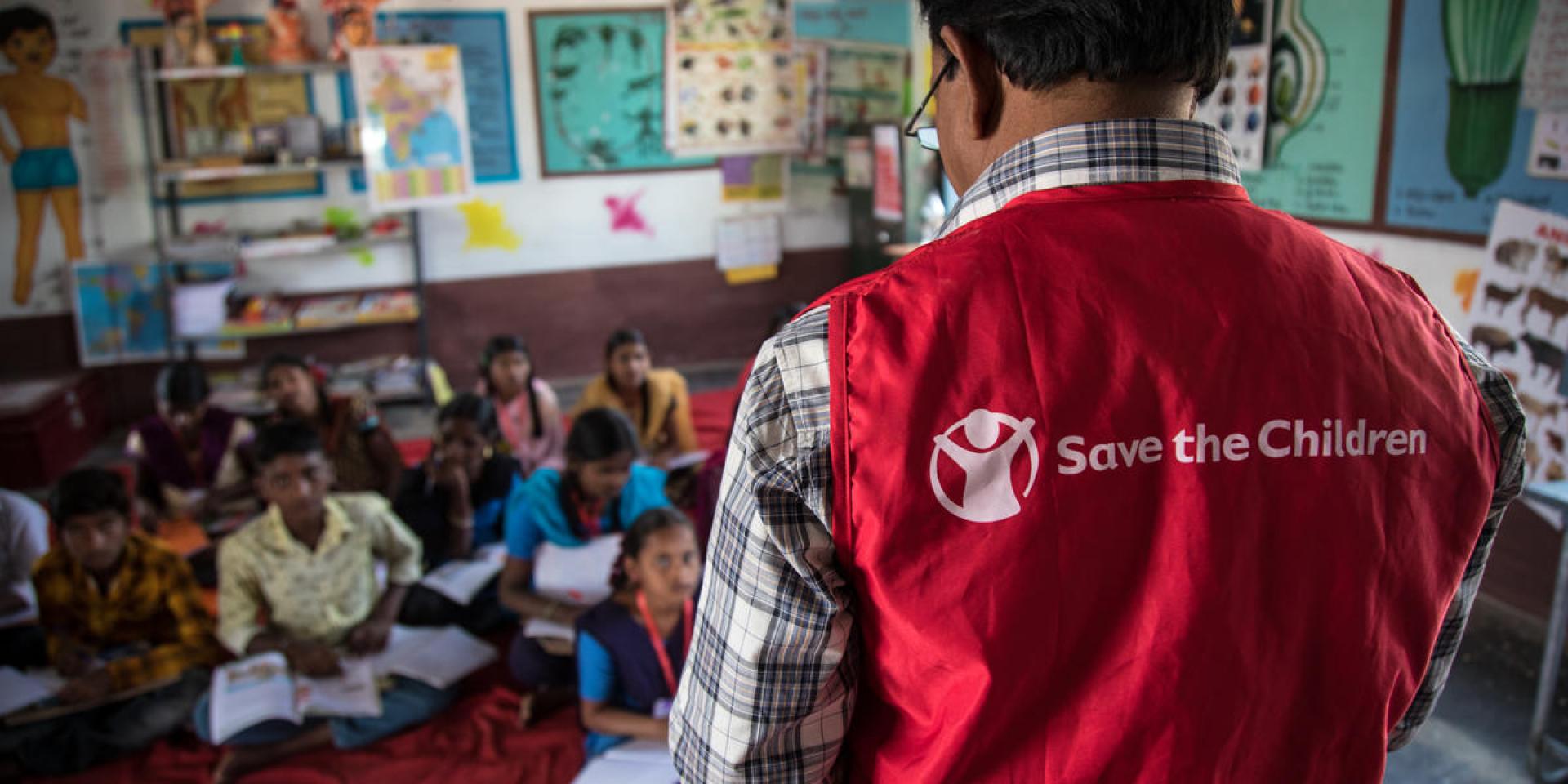 Un insegnante formato da Save the Children insegna inglese in una classe di un piccolo villaggio in India