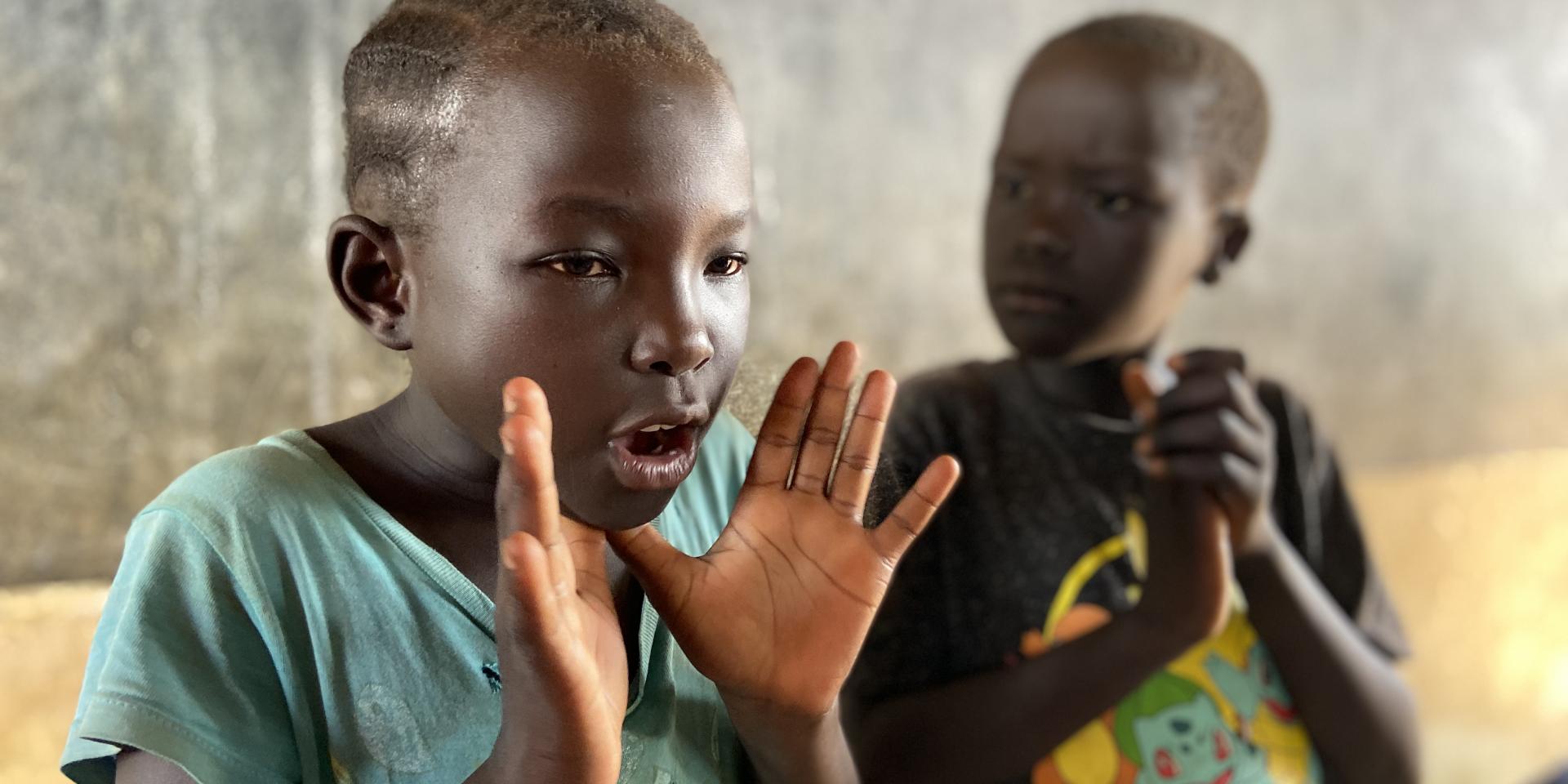 Una bambina parla durante una lezione in uno dei centri per la prima infanzia in un campo profughi in Uganda