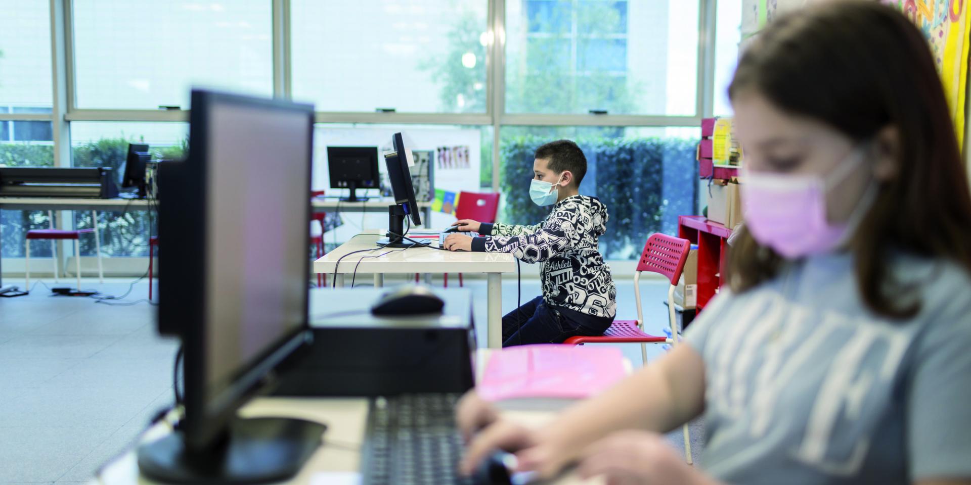 Ragazzi al computer durante un laboratorio digitale nel Punto Luce di Torre Maura