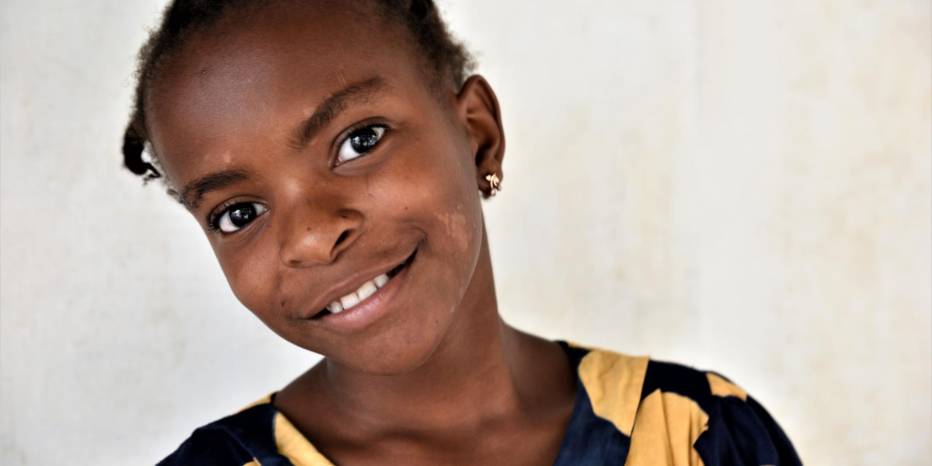 Primo piano di una bambina sorridente di 11 anni in uno Spazio a Misura di Bambino a Capo Delgado