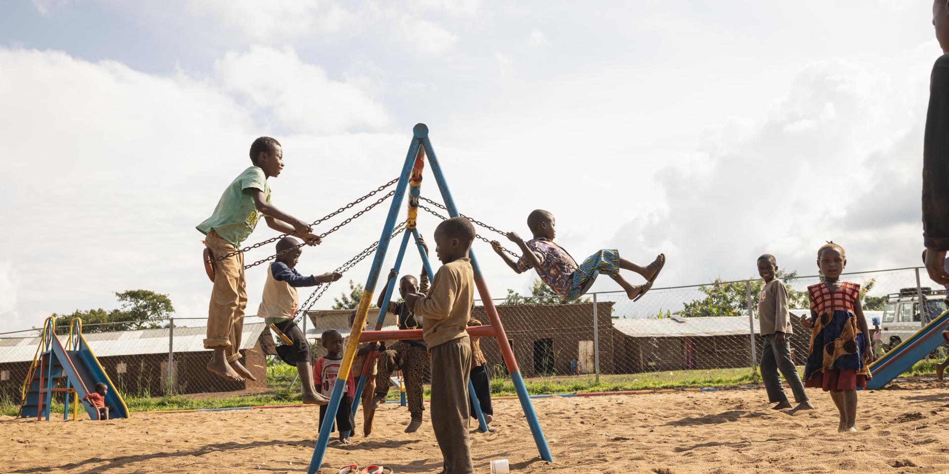 Bambini giocano e vanno in altalena in uno Spazio a Misura di Bambino in un campo rifugiati in Uganda