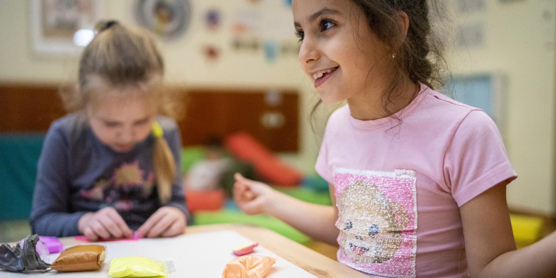 Due bambine ucraine svolgono attività ricreative in uno Spazio a Misura di Bambino in Germania