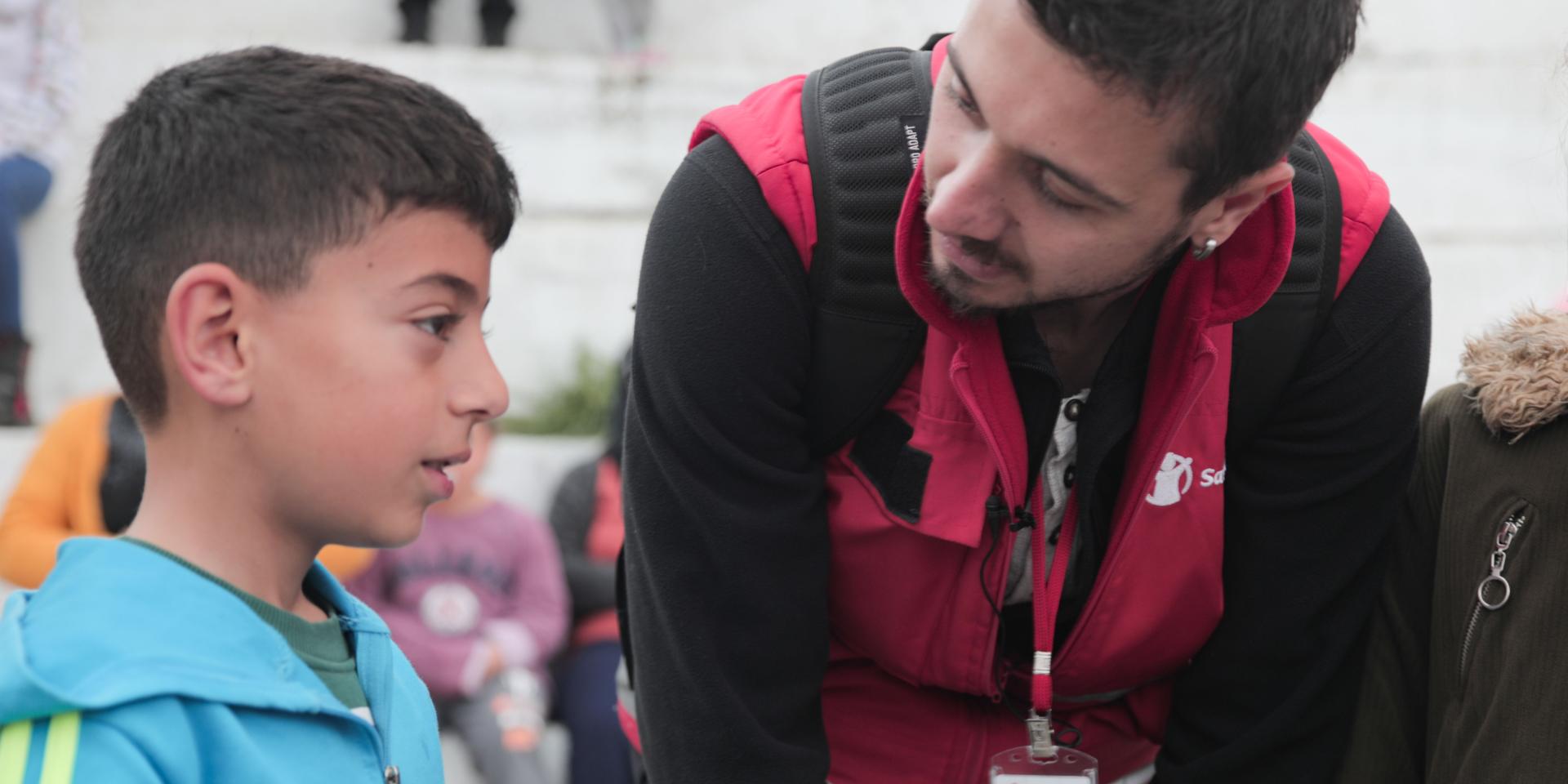Un operatore che si occupa di salute mentale e supporto psicosociale di Save the Children parla con un bambino colpito dal terremoto in Turchia