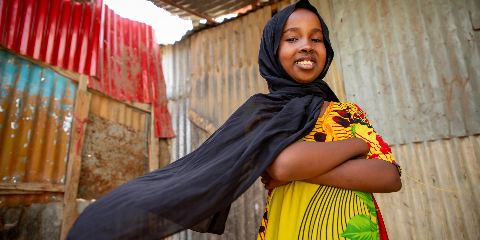Una bambina di 10 anni sorride nella sua casa nel Puntland, Somalia. La bambina frequenta uno Spazio a Misura di Bambino in un campo realizzato per persone in fuga dalla guerra e dal cambiamento climatico