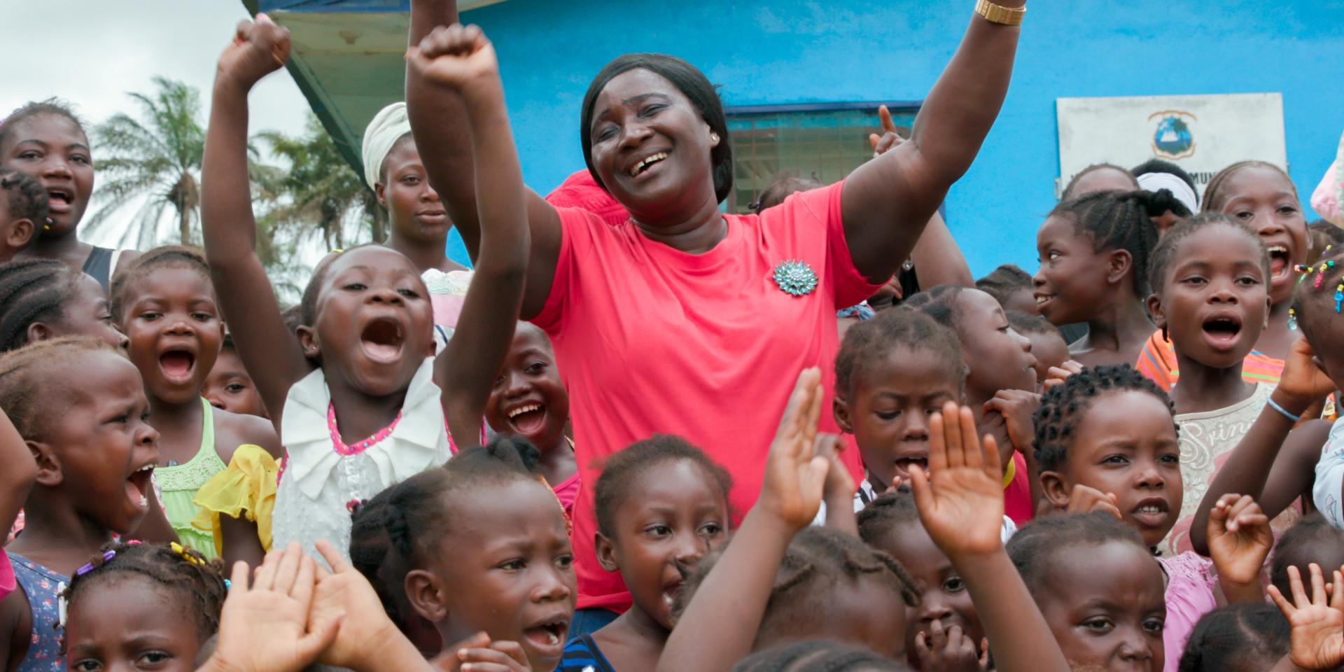 Un’ostetrica festeggia insieme a tantissime bambine che portano il suo stesso nome, poiché sono tutte nate grazie al suo aiuto in un villaggio in Liberia.