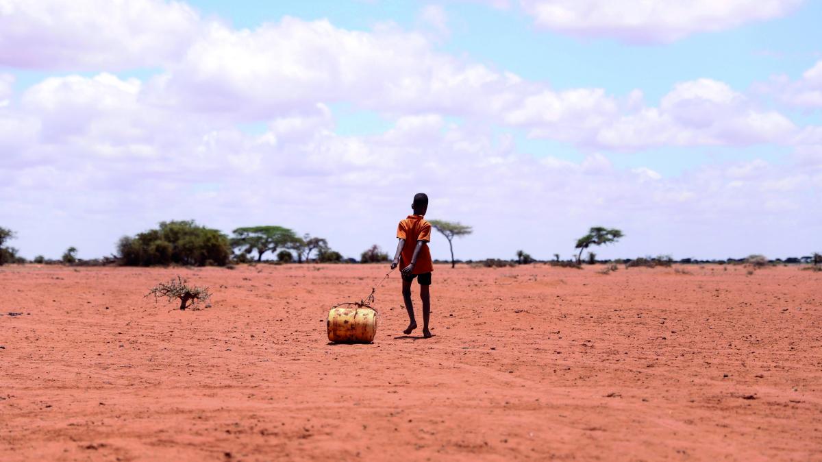 Un ragazzo trasporta acqua in un barile in Wajir, Kenya