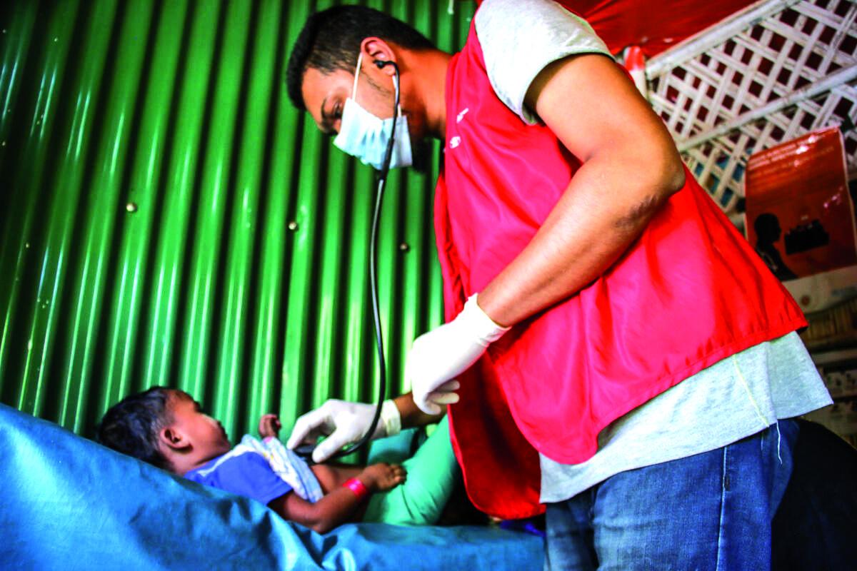 Un Operatore sanitario inocula una dose di vaccino ad un bimbo