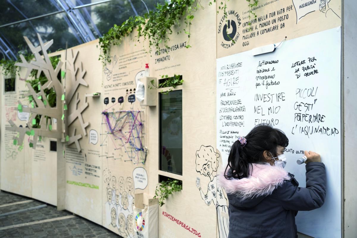 Bimba scrive su un cartellone durante l'evento "Insieme per gli SDGs" tenutosi a Roma