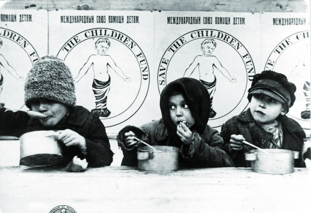 Durante la carestia in Russia, due bambini mangiano da una gavetta grazie all'aiuto di Save the Children per portare aiuto ai bambini affamati