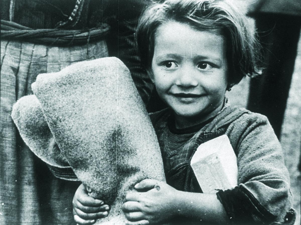 Una bambina stringe una coperta ricevuta grazie agli interventi di Save the Children per la ricostruzione in Europa dopo la Seconda Guerra Mondiale