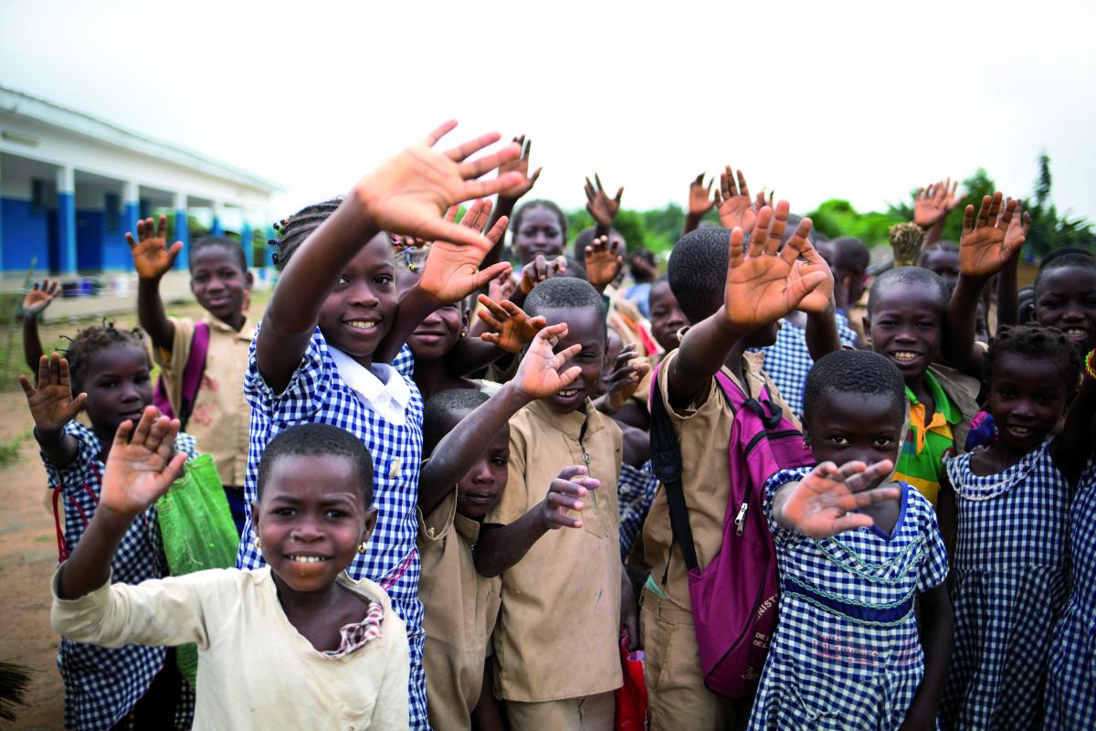 Ragazzi di un villaggio africano che salutano verso la camera