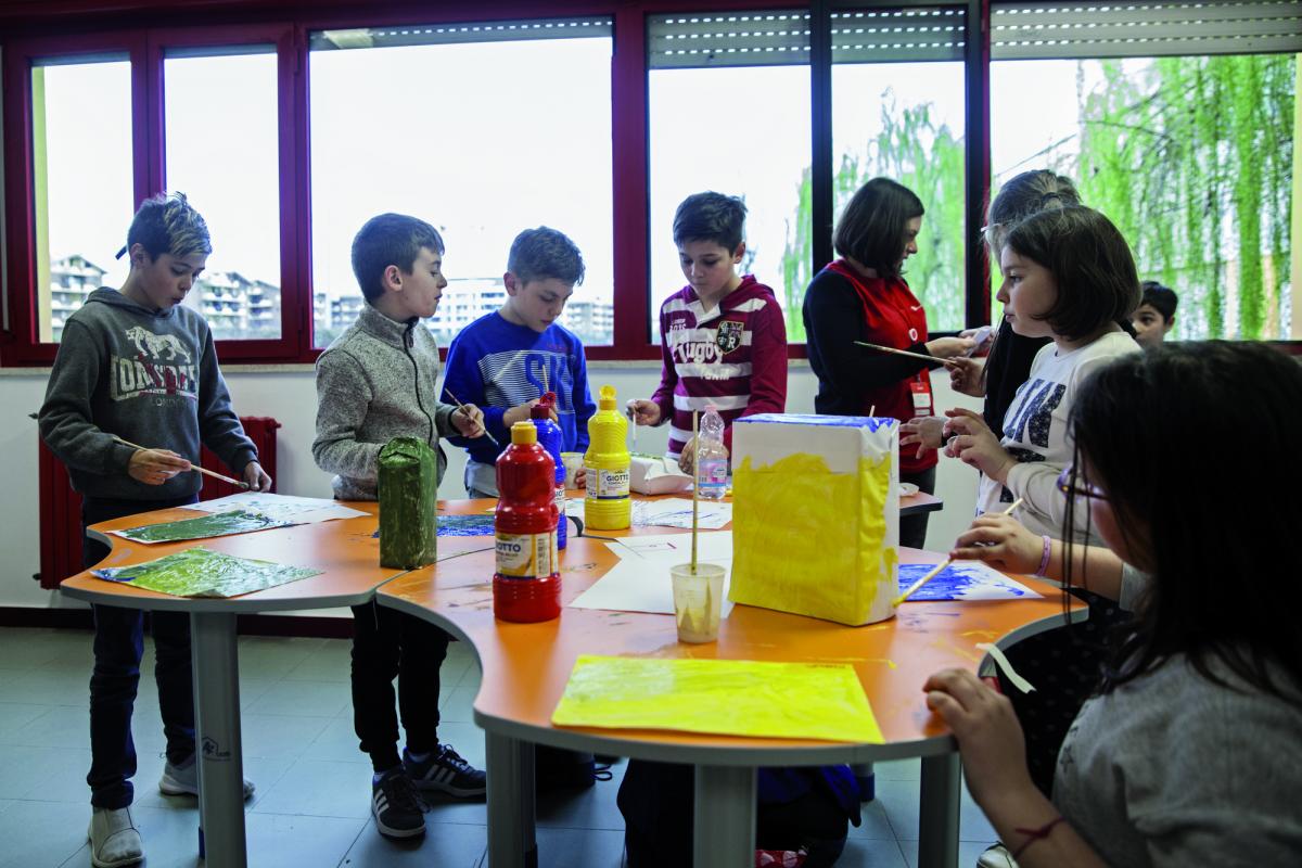 Bimbi riuniti attorno ad un tavolo a colorare, durante l'inaugurazione del progetto Fuoriclasse ad Aprilia