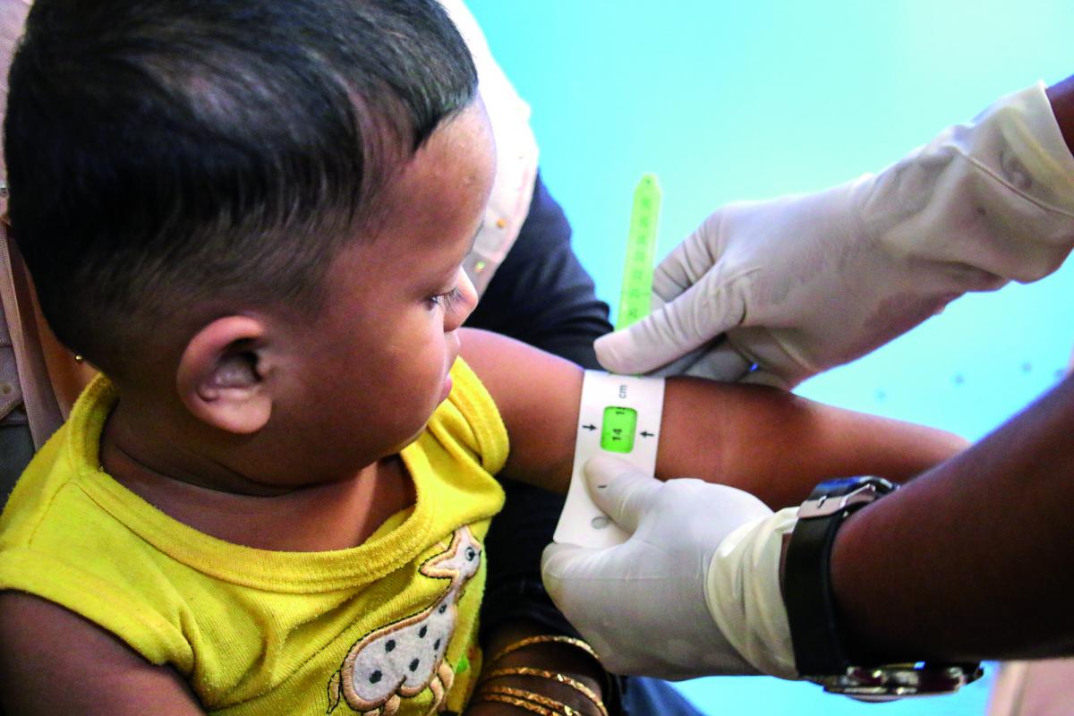 Un operatore di Save The Children misura la circonferenza del braccio di un bimbo durante dei controlli anti-malnutrizione nel campo profughi di Rohingya, Bangladesh
