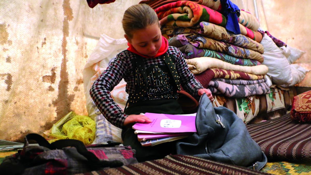Lara, 7 anni nella sua tenda, mentre i prepara ad andare a scuola