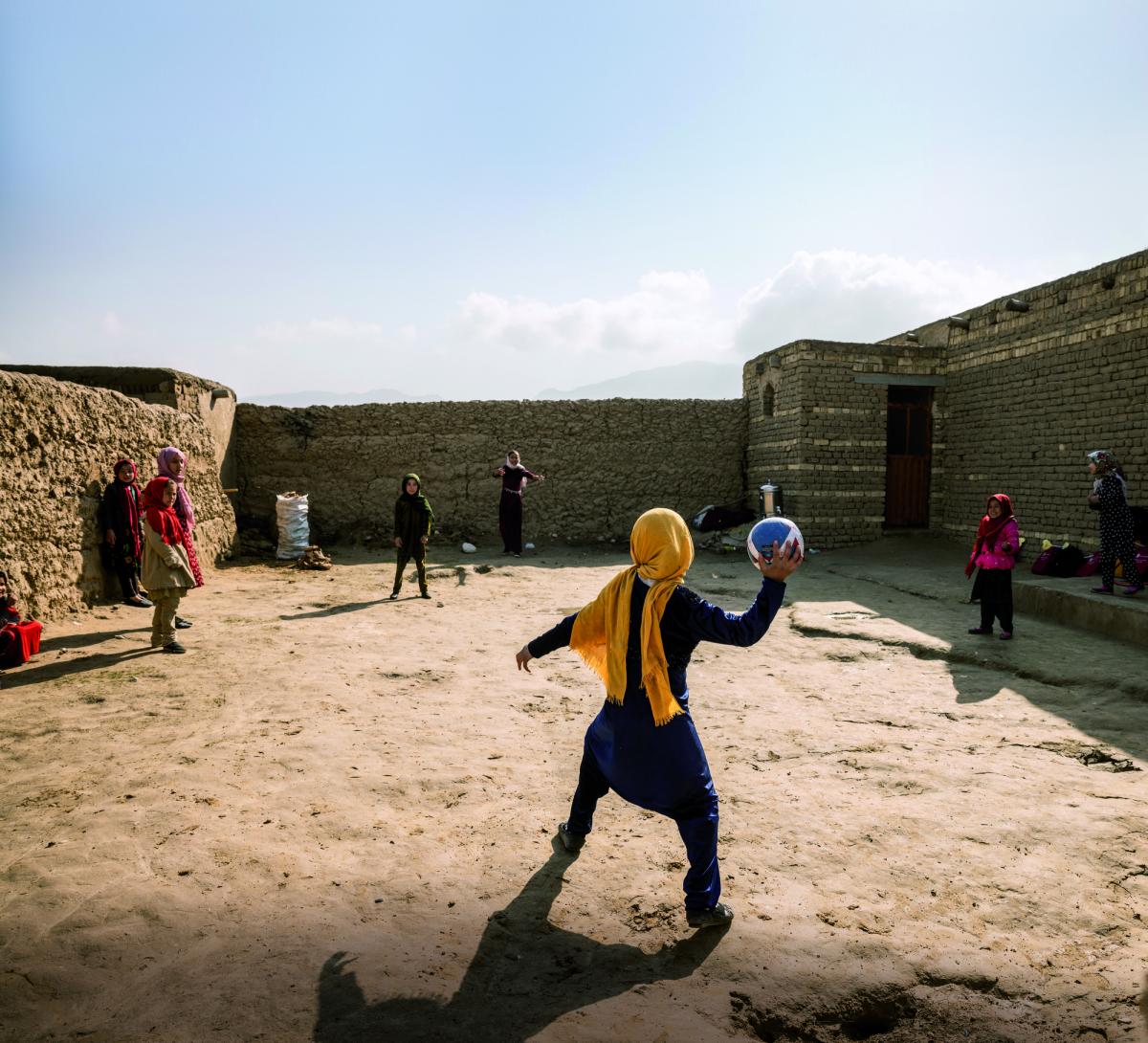 Alcune bambine giocano in uno Spazio a Misura di Bambino, un luogo sicuro e inclusivo dove imparare, giocare ed essere protetti realizzato da Save the Children in un campo sfollati in Afghanistan.