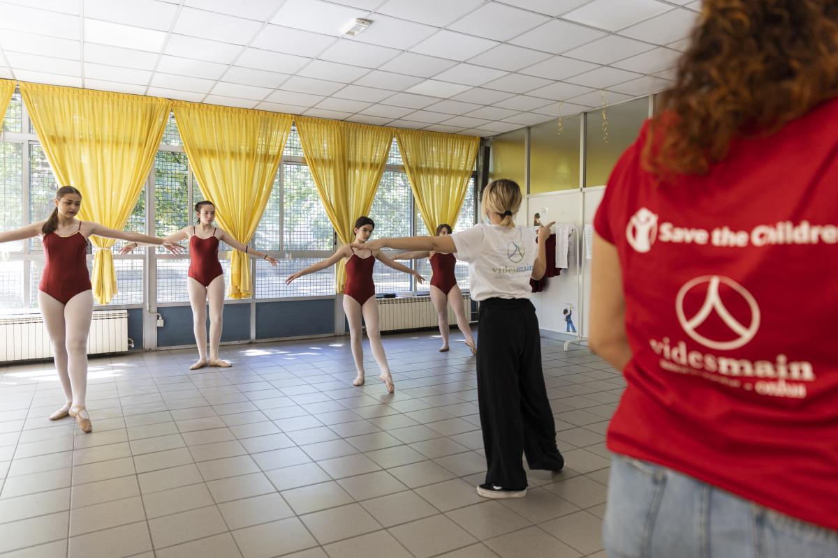 Delle bambine eseguono passi di danza sotto la supervisione di un'insegnante