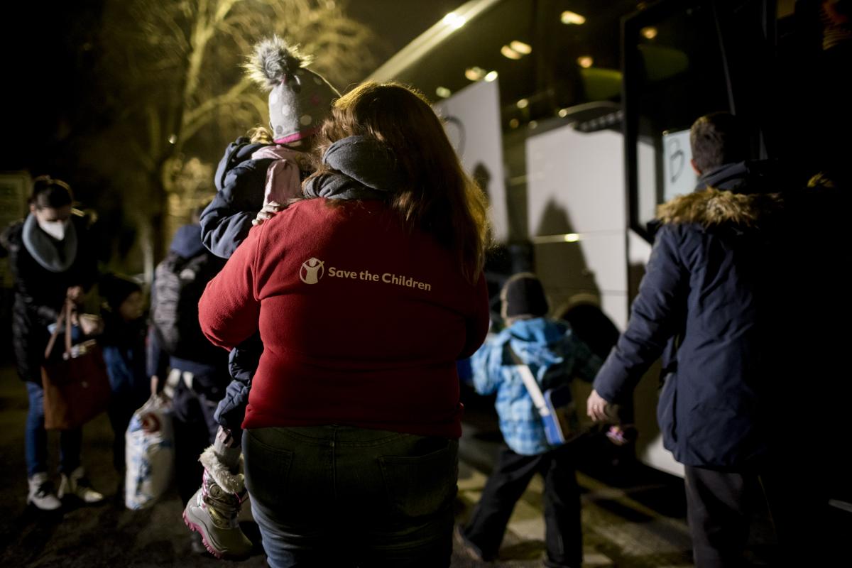 Una bimba in braccio ad una volontaria di save The Children